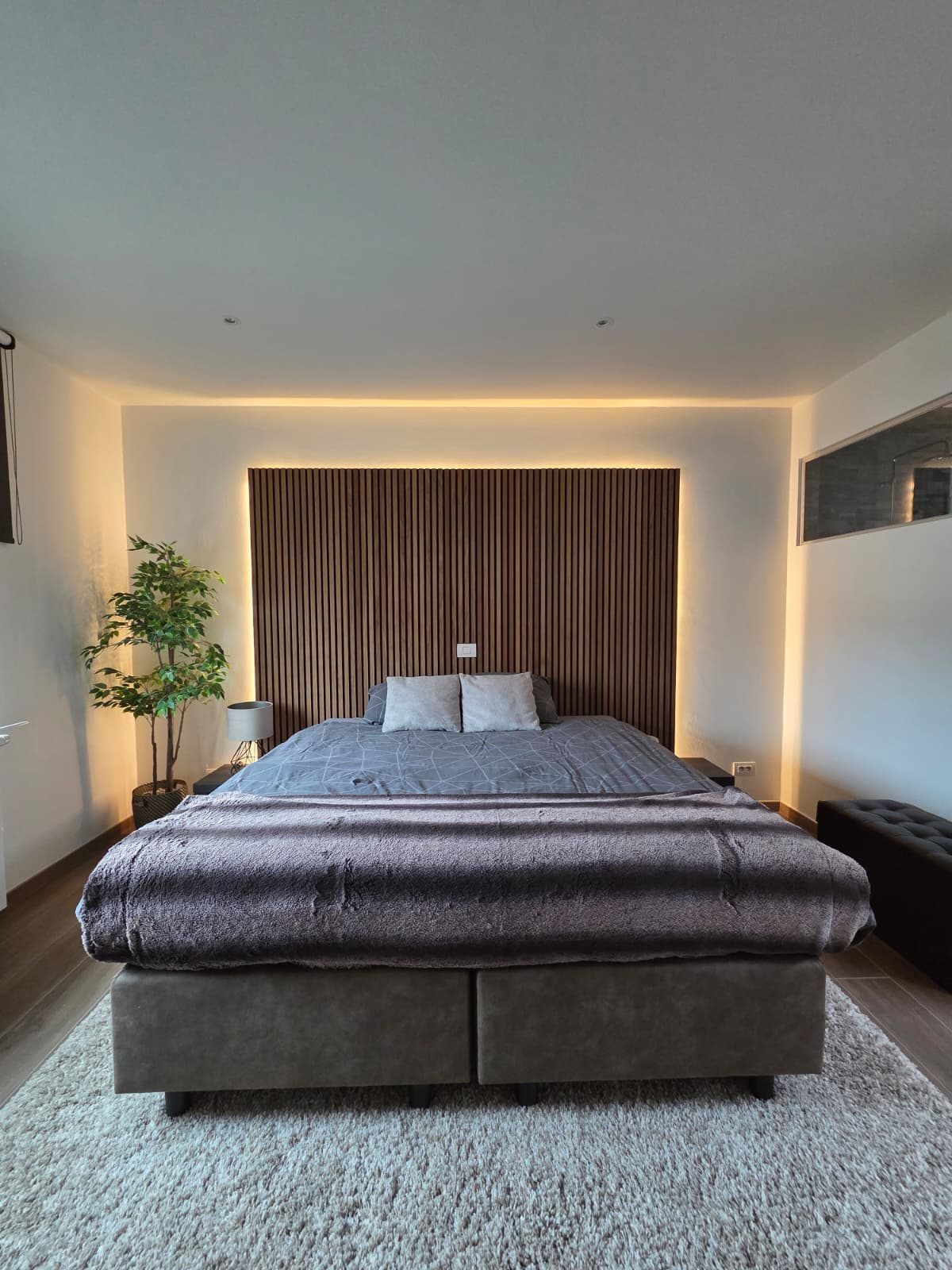 Slaapkamer met verlichte lattenwand