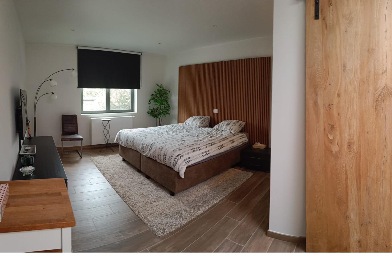 Kamer met boxspring-bed en houten lattenwand